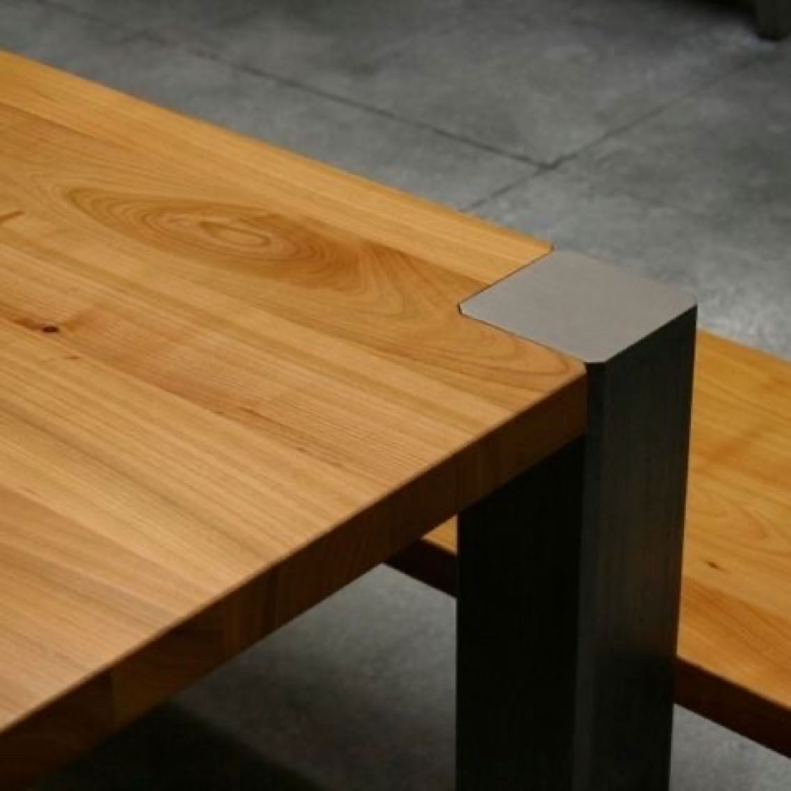 Table en bois de cerisier avec des pieds en métal brut 