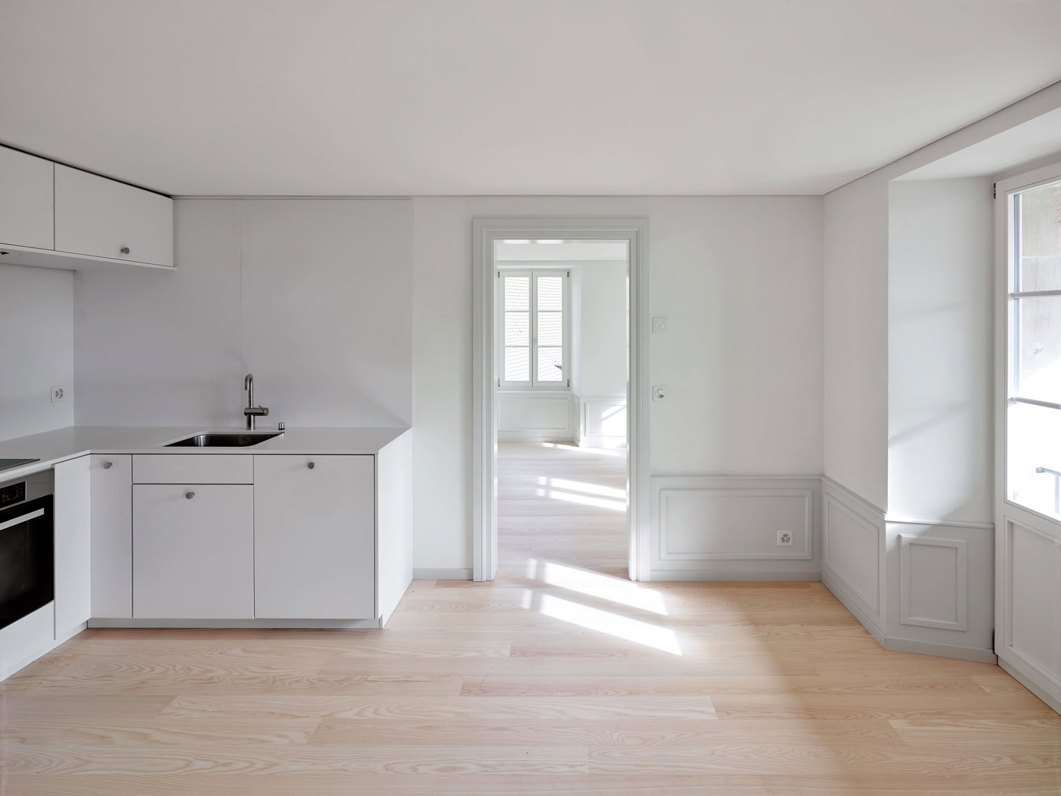 Cuisine moderne, avec soubassement en bois et encadrement de porte 