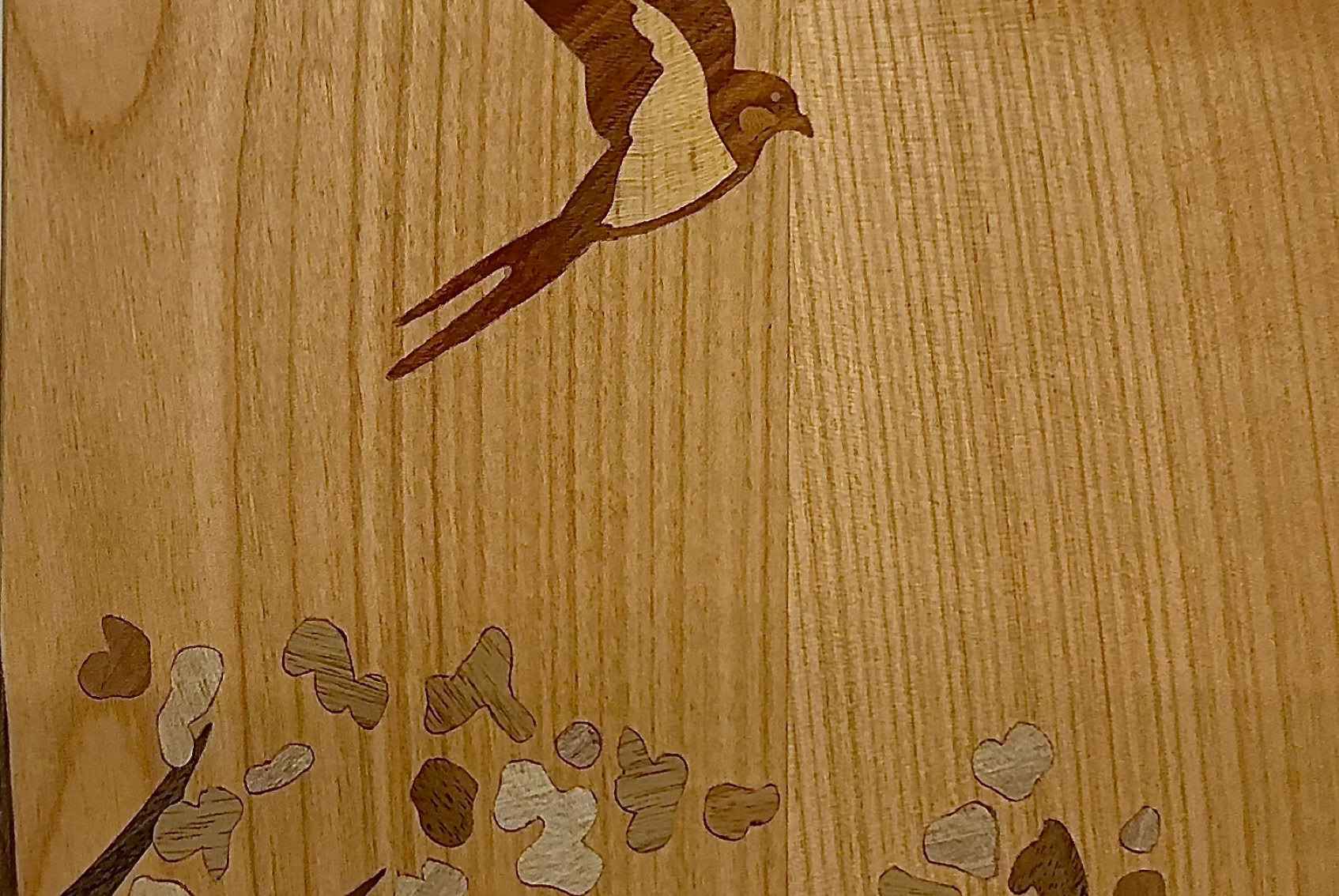 Oiseau en vol au-dessus d'un arbre stylisées sur une porte en cerisier massif