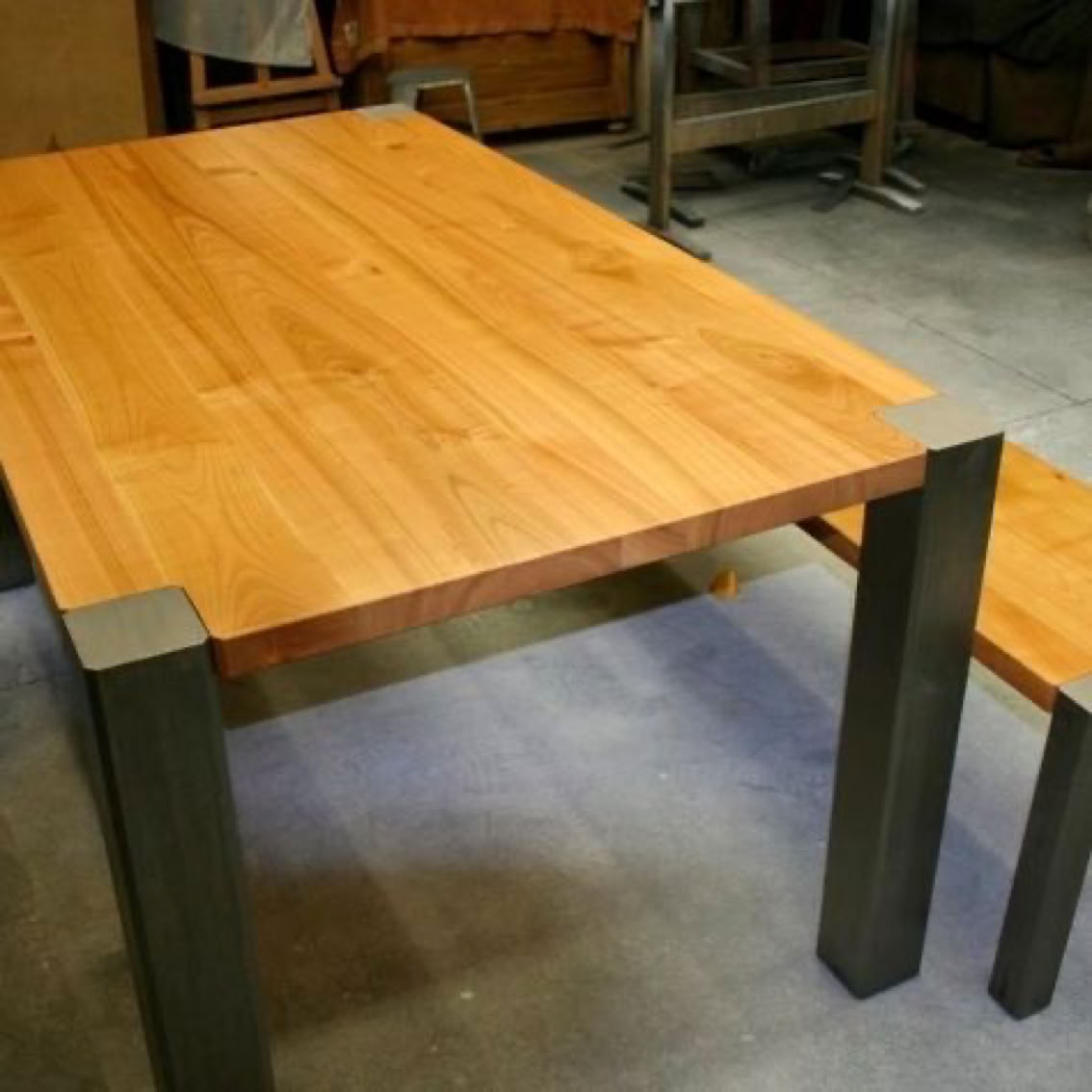 Table en bois de cerisier avec des pieds en métal brut 